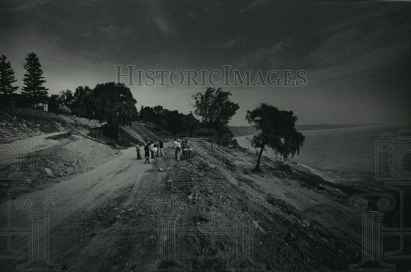 Load image into Gallery viewer, 1984 Press Photo Officials and residents walk on temporary roads used for trash

