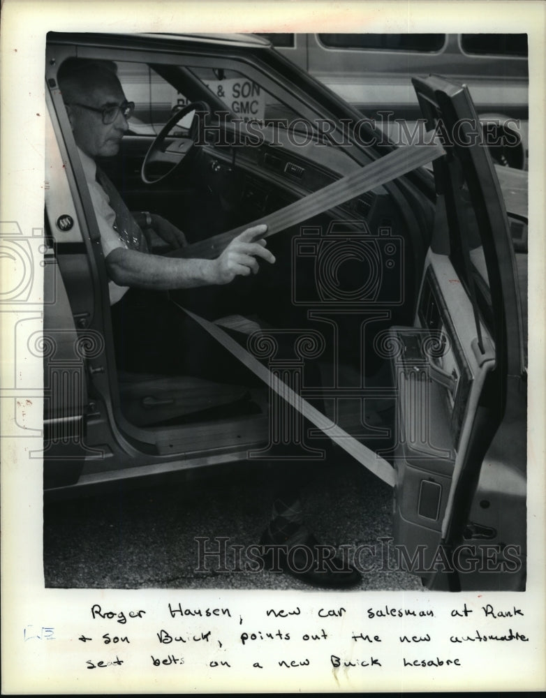 1989 Press Photo Roger Hansen demonstrates automatic seat belt on Buick Lesabre