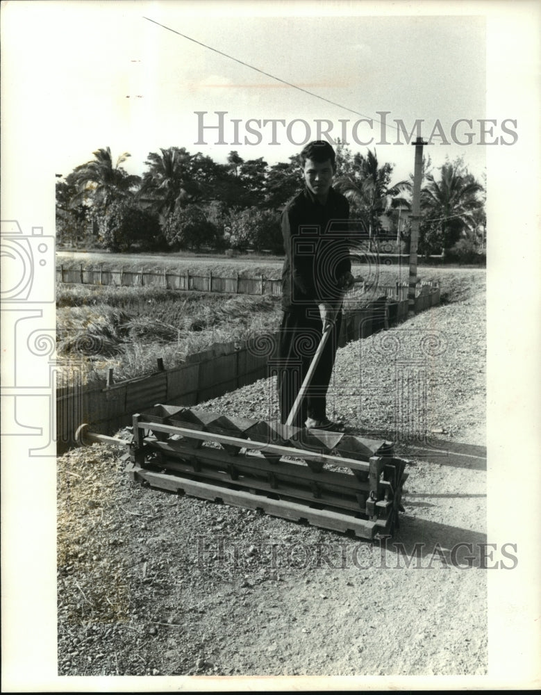1978 Press Photo A Cambodian worker shown with a mechanical six row rice planter