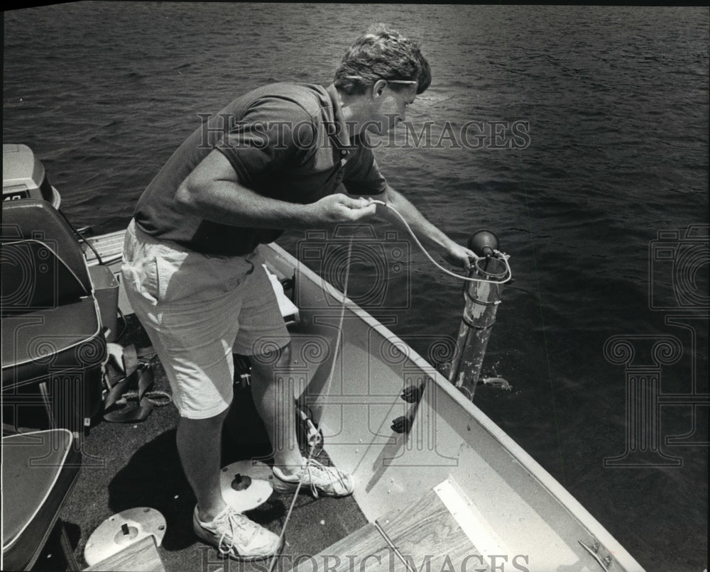 1989 Press Photo Biologist Bob Wakeman gets water sample from Big Cedar Lake, Wi- Historic Images