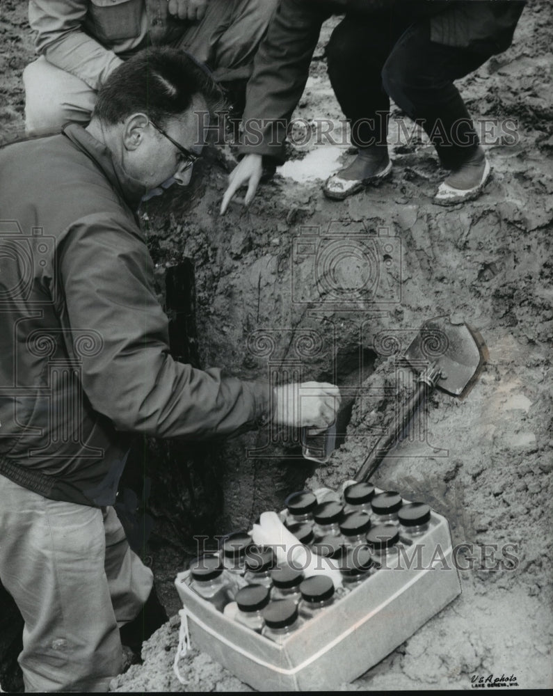 1957 Press Photo Geologist Dr. Robert Black Unearths Old Log At Lake Geneva