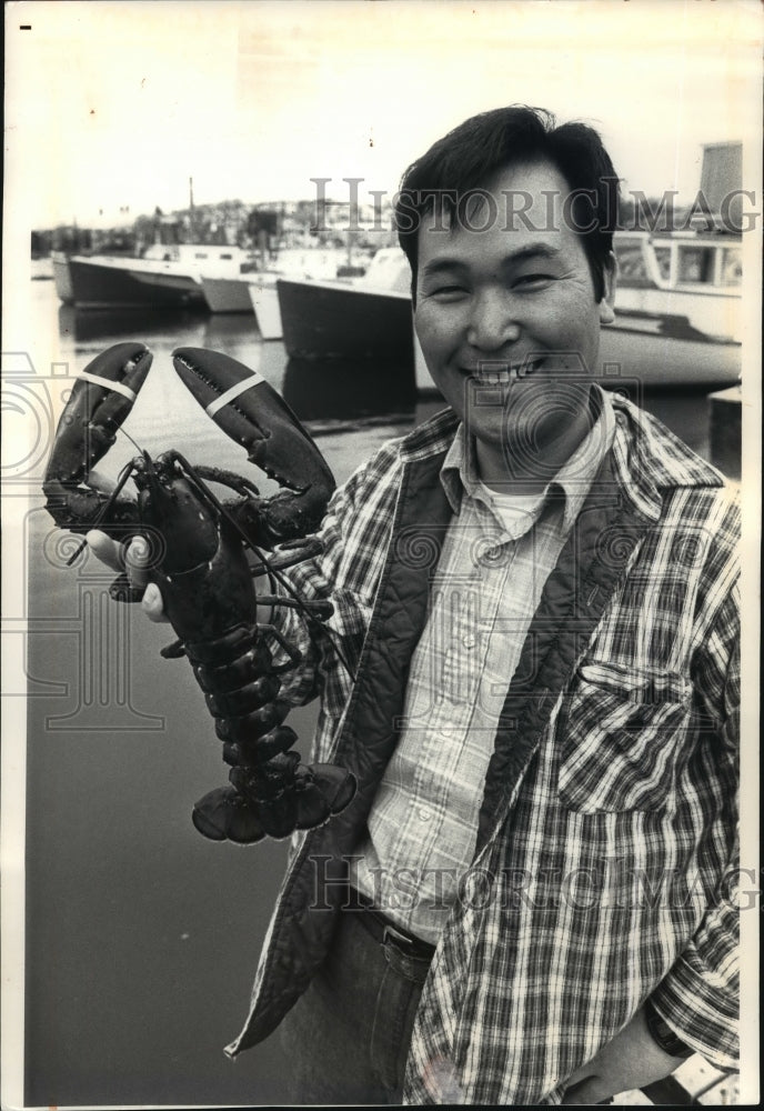 1986 Press Photo Nick Sasao held a lobster at the pier in Gloucester, Massachuse- Historic Images