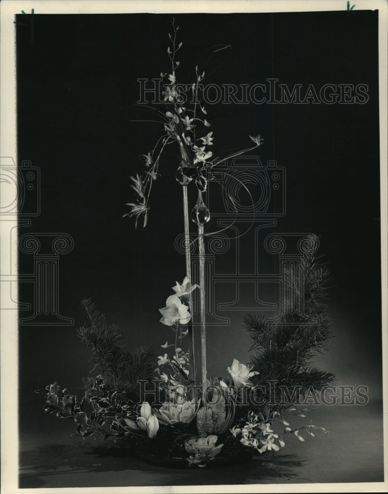 1987 Press Photo Orchids and white amaryllis mix with holly and pine cones- Historic Images