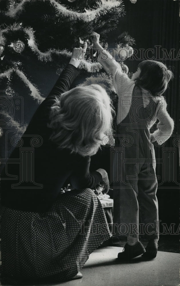 1975 Press Photo Mother and daughter hang ornament on Christmas Tree - Historic Images