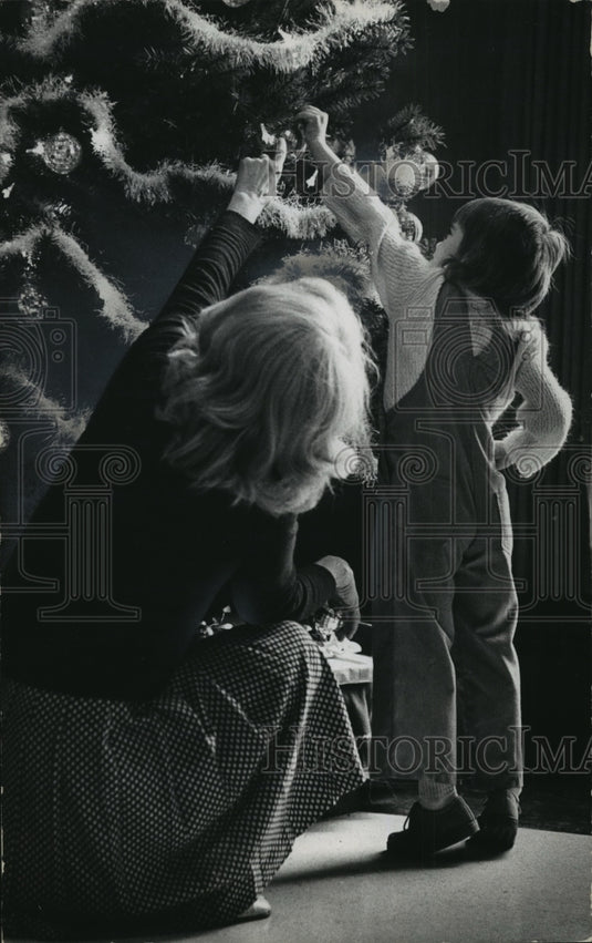 1975 Press Photo Mother and daughter hang ornament on Christmas Tree - Historic Images