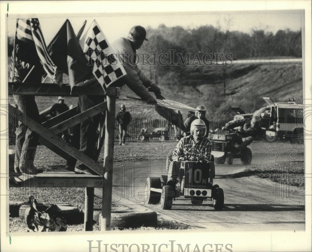 1986 Press Photo racers on lawn mowers roar around the bend of the track- Historic Images