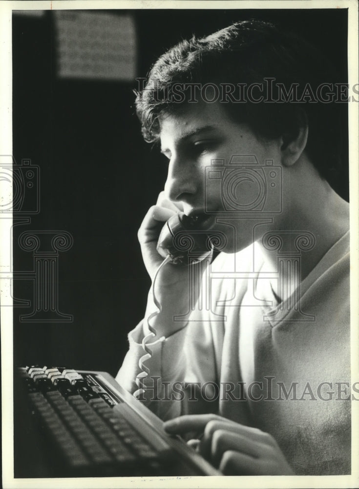 1983 Press Photo Neal Patrick has a phone next to his computer.- Historic Images