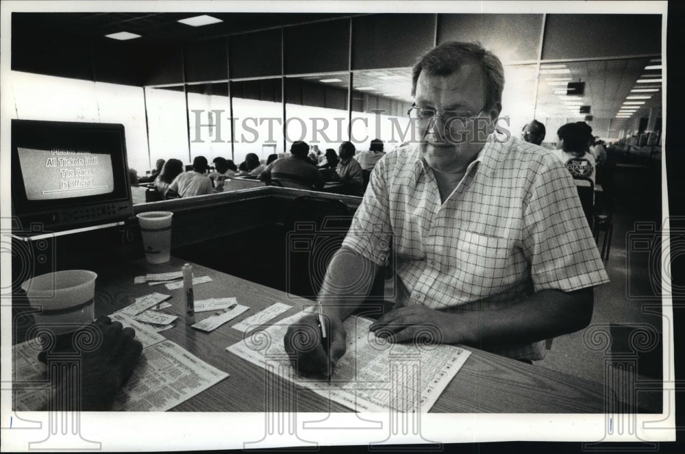 1989 Press Photo Ron Benish Making Notes at Dubuque Greyhound Park in Iowa- Historic Images