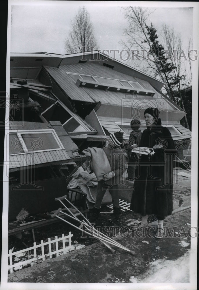 1964 Press Photo Family looks on home after destructive earthquake. Alaska