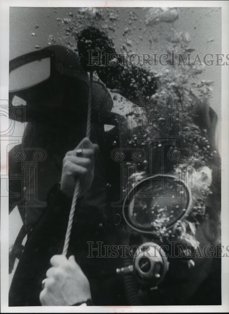 1972 Press Photo Diving- Air bubbles rise as a scuba diver clings to a rope - Historic Images