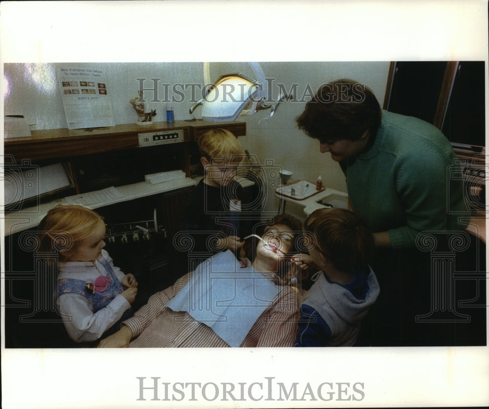 1993 Press Photo Children try using dental instruments on Laurie DeMoss- Historic Images