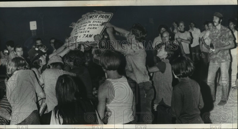 Load image into Gallery viewer, 1970 Press Photo Protesters tear down a sign at Water Tower Park in Milwaukee
