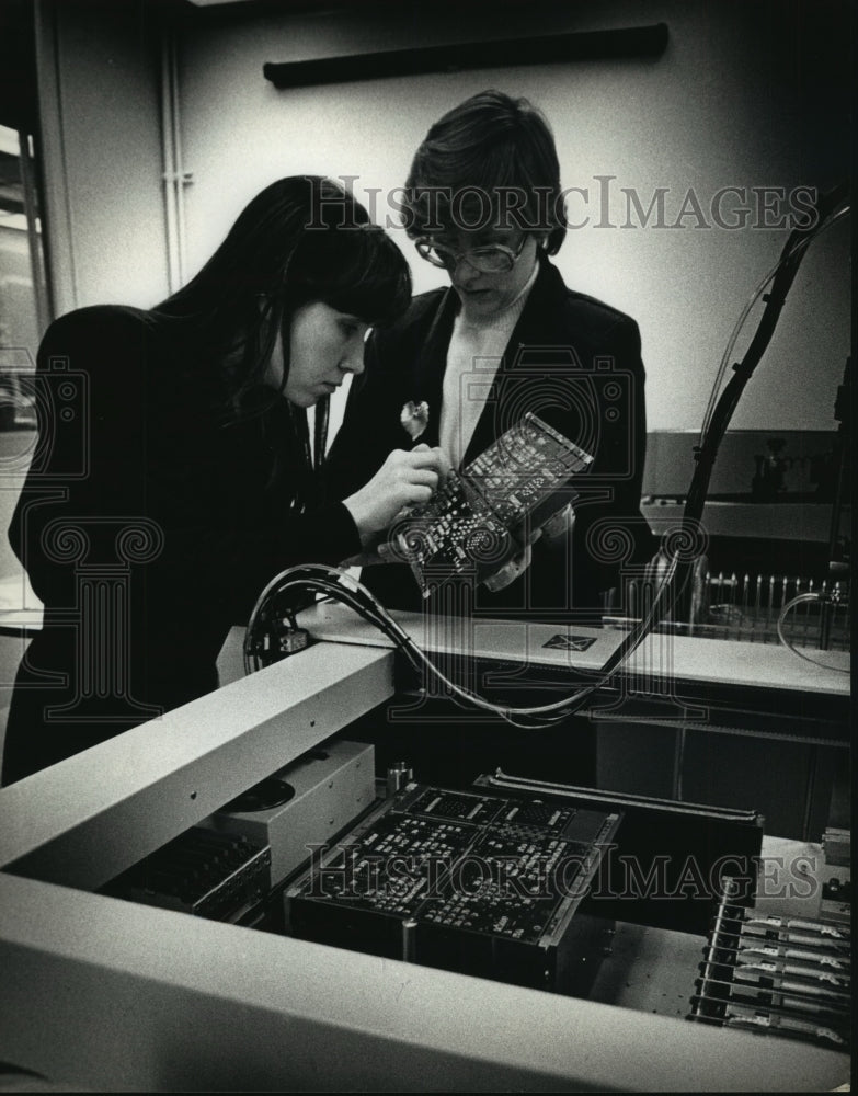 Load image into Gallery viewer, 1990 Press Photo Chris Wodke and Gail Robison Check Electronics at Eaton Crop.
