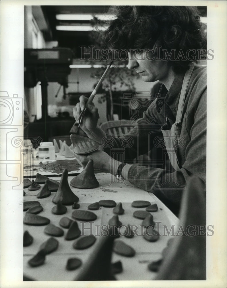 1985 Press Photo Kamholtz texturizing clay dinosaur body parts with stiff brush- Historic Images