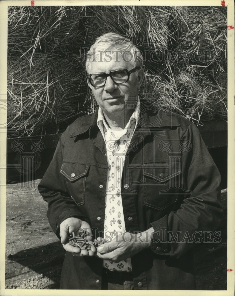Load image into Gallery viewer, 1980 Press Photo Lawrence Driessen with hay pellets that he produced - mjb05394
