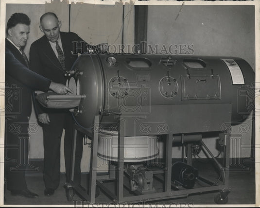 1937 Press Photo Terry McGurgan and Frank Schneeberger, look at "iron lung."- Historic Images