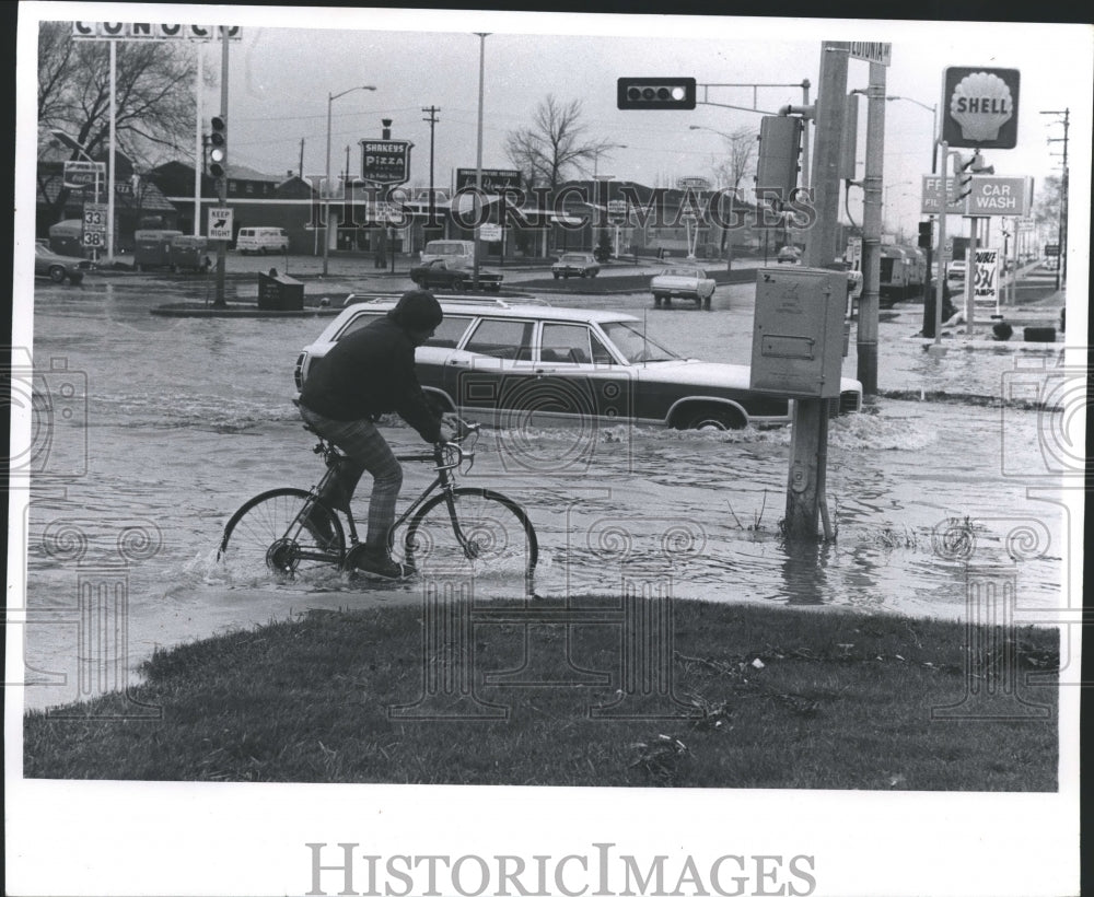 1973 Press Photo Bicyclist ,Motorist Navigate Floodwater In Milwaukee, Wisconsin- Historic Images