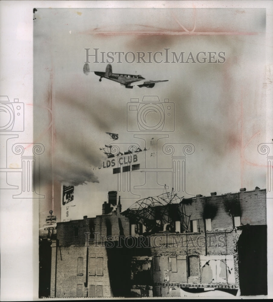 1962 Press Photo Plane Flies Over Building Dropping Chemicals to Retard Fire- Historic Images