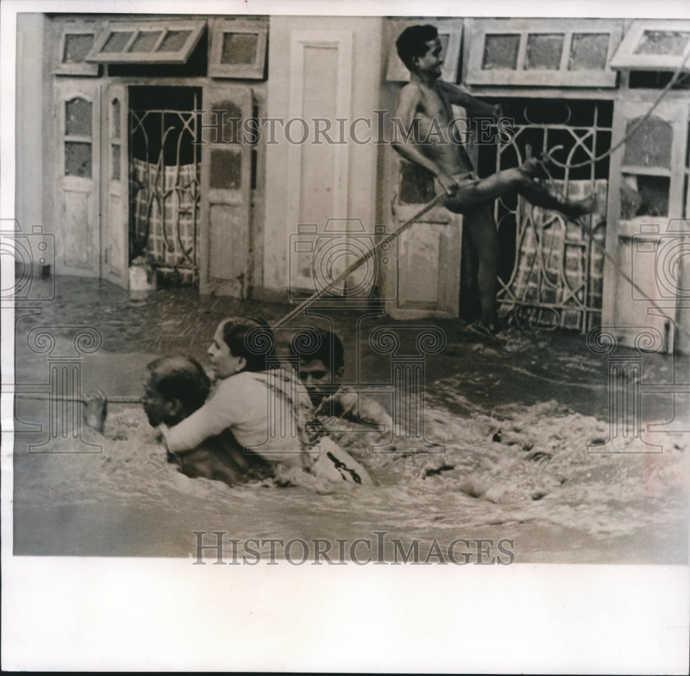 1961 Press Photo Flooding in Poona, India as Men help Woman in Street with Rope- Historic Images