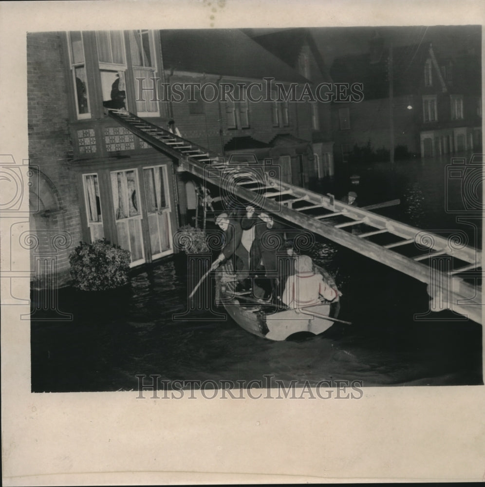 1958 Press Photo Flood survivors paddle along street to return home in Holland.- Historic Images