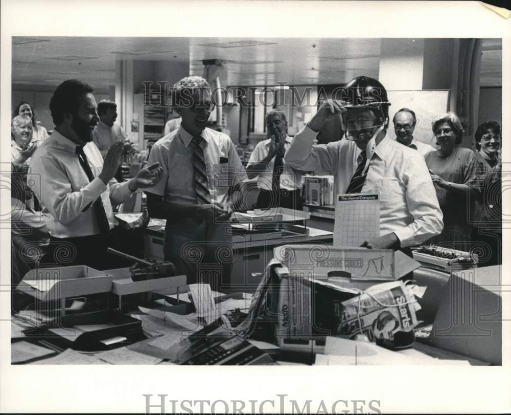 1985 Press Photo Journal editor Patrick Graham wearing a football helmet at work- Historic Images