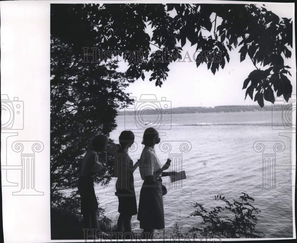 1965 Press Photo Girls on shore, watch boat cruise past on Green Lake, Wisconsin