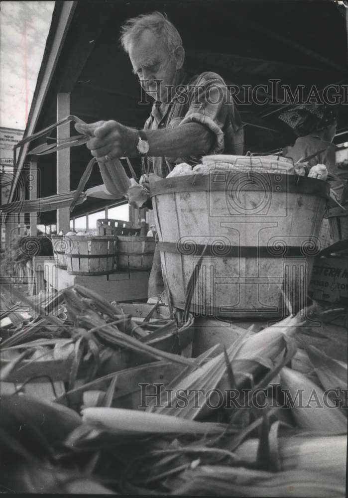 Load image into Gallery viewer, 1972 Press Photo Farmer husks corn, Green Markets, Milwaukee, Wisconsin
