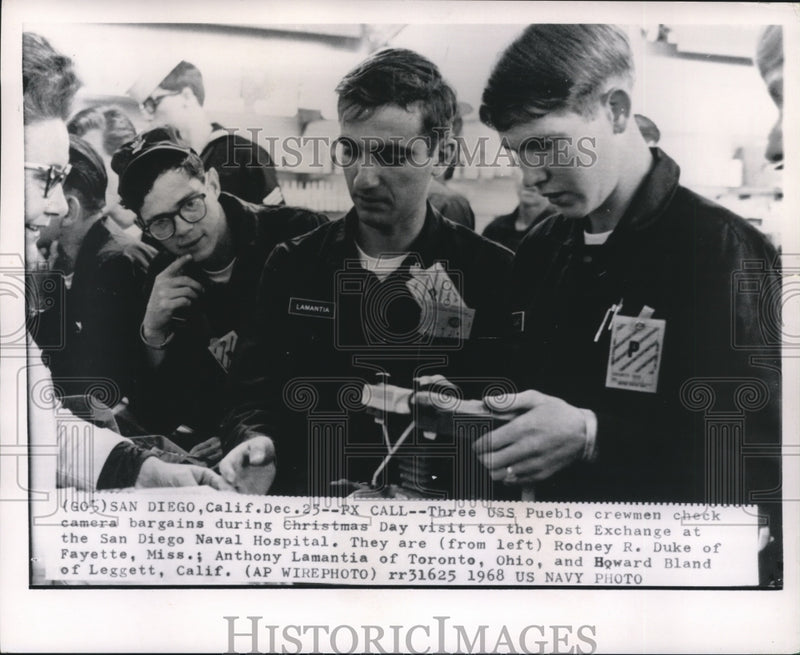 Load image into Gallery viewer, 1968 Press Photo USS Pueblo crewmen check camera bargains in San Diego
