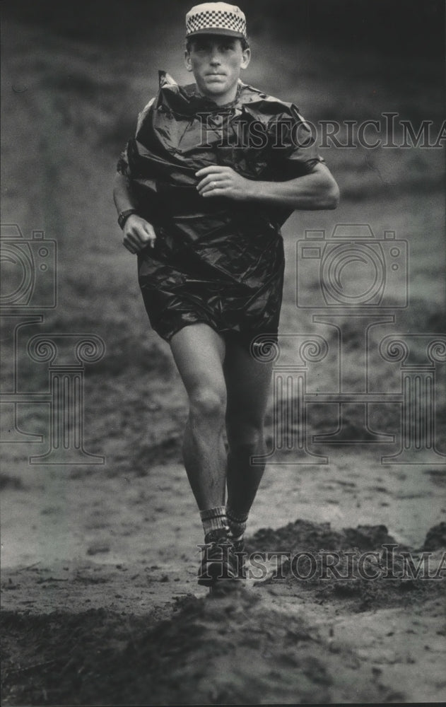 1986 Press Photo Racer uses trash bag in rain for Ice Age Trail Run.- Historic Images