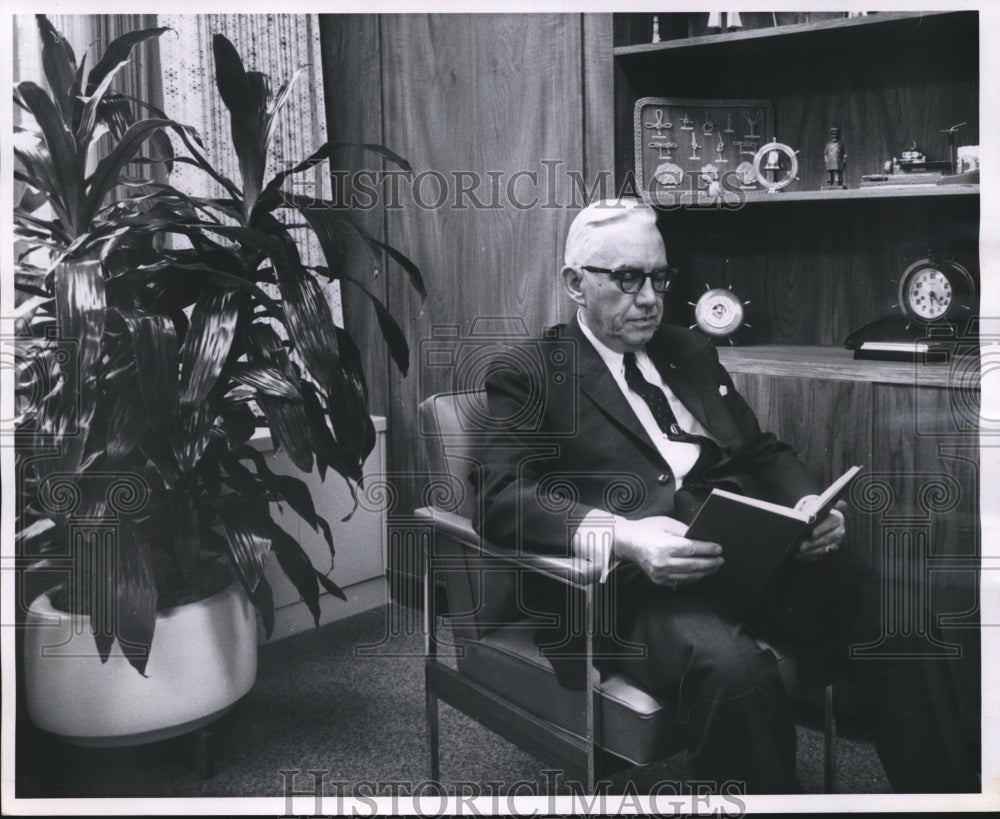1962 Press Photo Charles Harris, senior VP at Marine Bank in office with plant