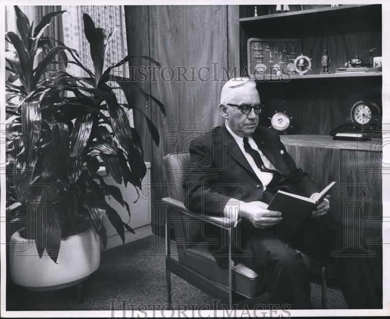 Load image into Gallery viewer, 1962 Press Photo Charles Harris, senior VP at Marine Bank in office with plant
