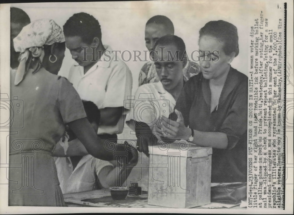 1957 Press Photo Woman voter dips finger in indelible ink before marking ballot- Historic Images