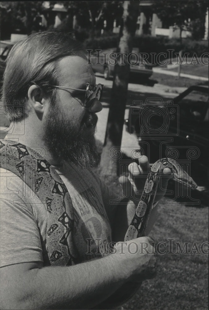 1985 Press Photo Scott Frost rescues his boa constrictor from city storm sewers- Historic Images