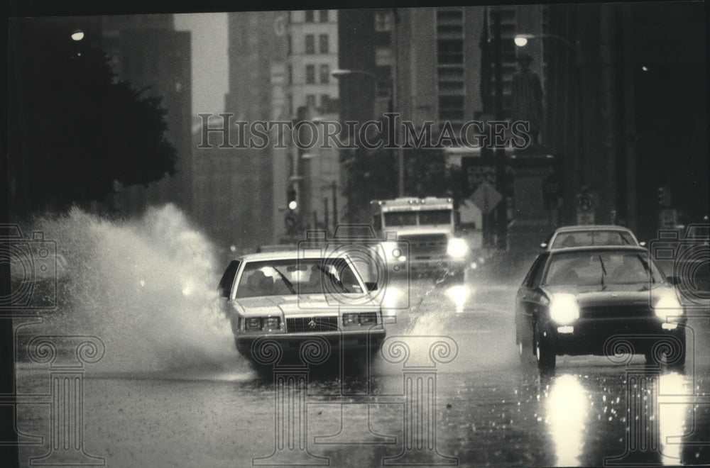1986 Press Photo Cars splashed on West Wisconsin Avenue during heavy rains.