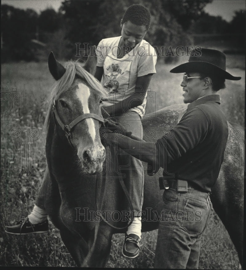 Load image into Gallery viewer, 1986 Press Photo Cowboy Issac Steele teaches Tony Tate how to adjust reins
