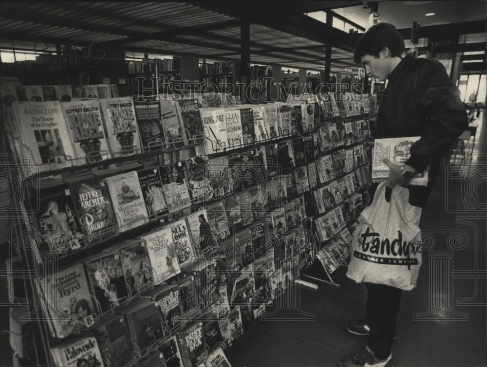 1985 Press Photo Rick Espinoza browsed paperbacks at Milwaukee Library- Historic Images