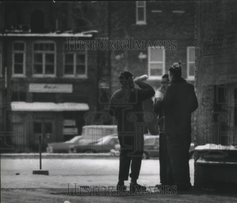 Load image into Gallery viewer, 1975 Press Photo Three men on snow packed street corner smoking and drinking, WI
