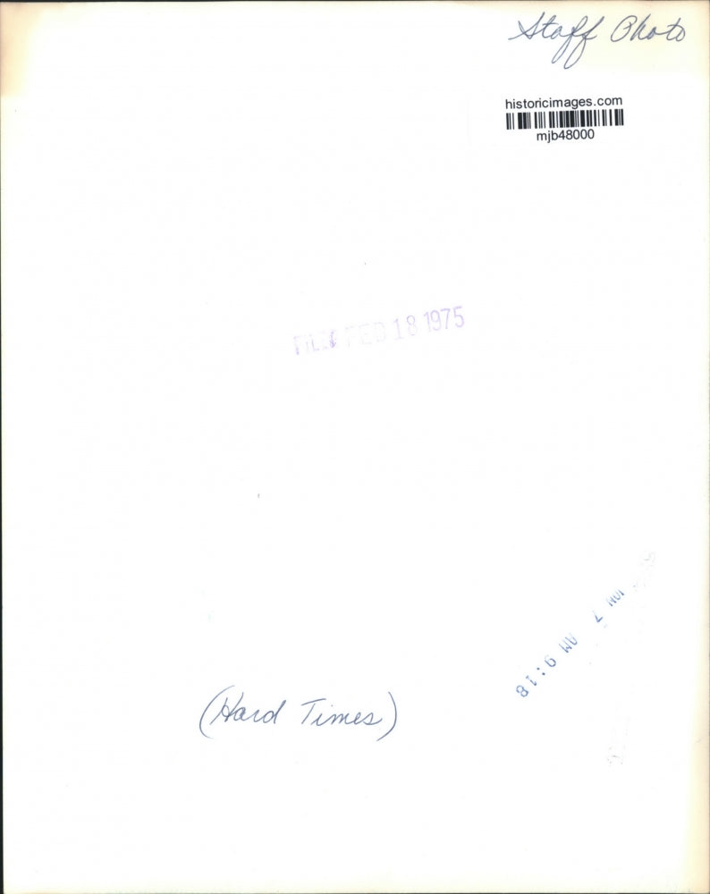 1975 Press Photo A man leaning against a utility pole on snow packed street, WI