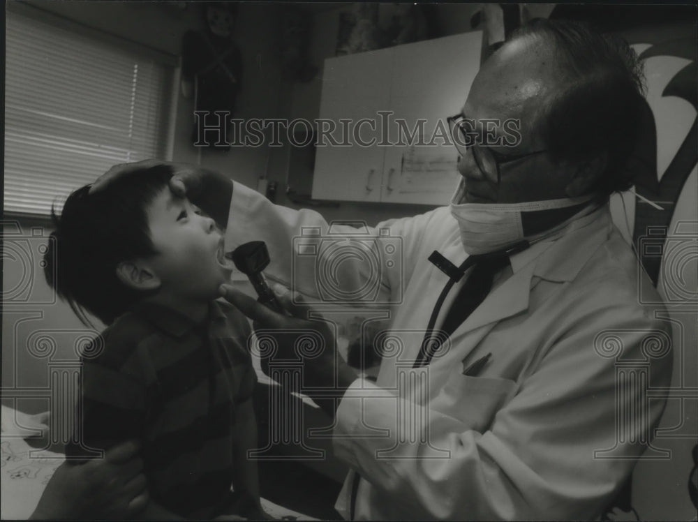 1994 Press Photo Marciano Visaya checks child at Milwaukee Immediate Care Center- Historic Images