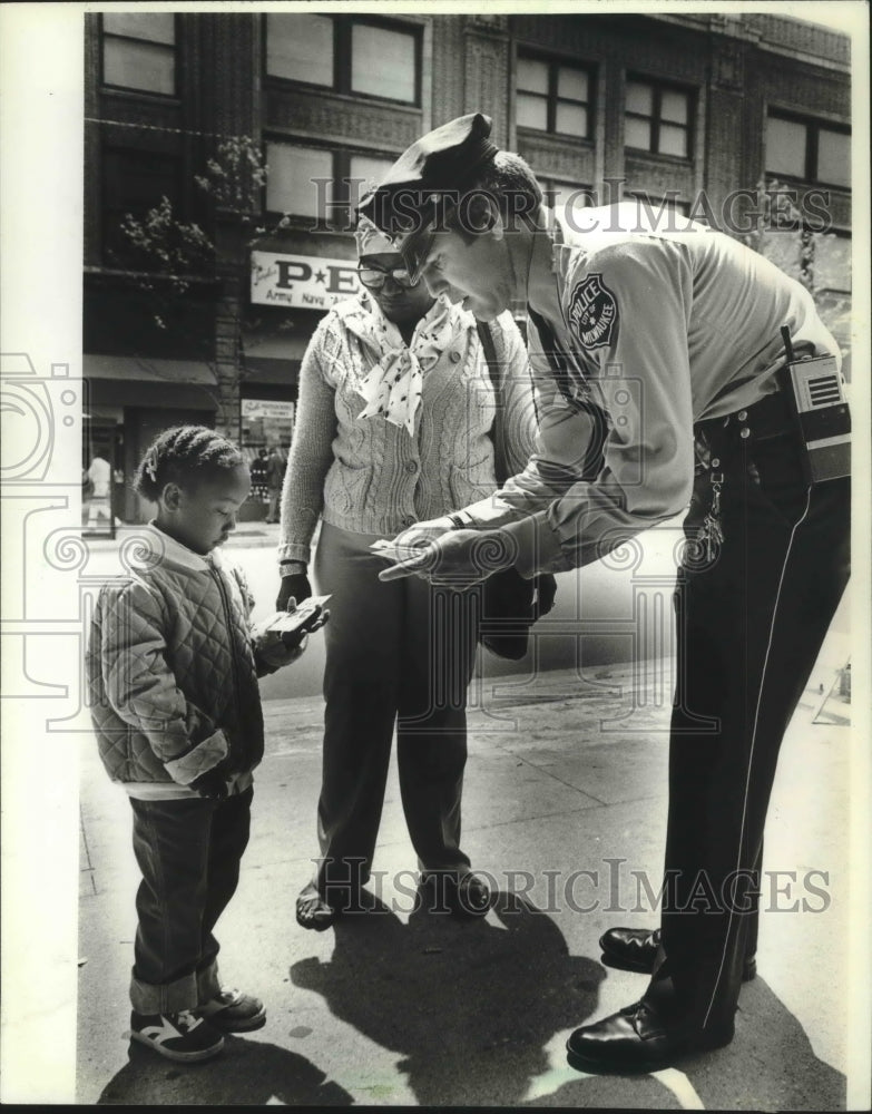 1962 Press Photo Police Officer Mike King Gives Baseball Cards to Nahmelah Fox