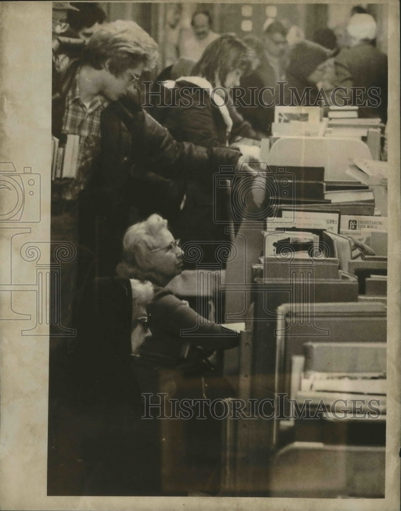 1976 Press Photo Bargain hunters examine discarded library books, Milwaukee.