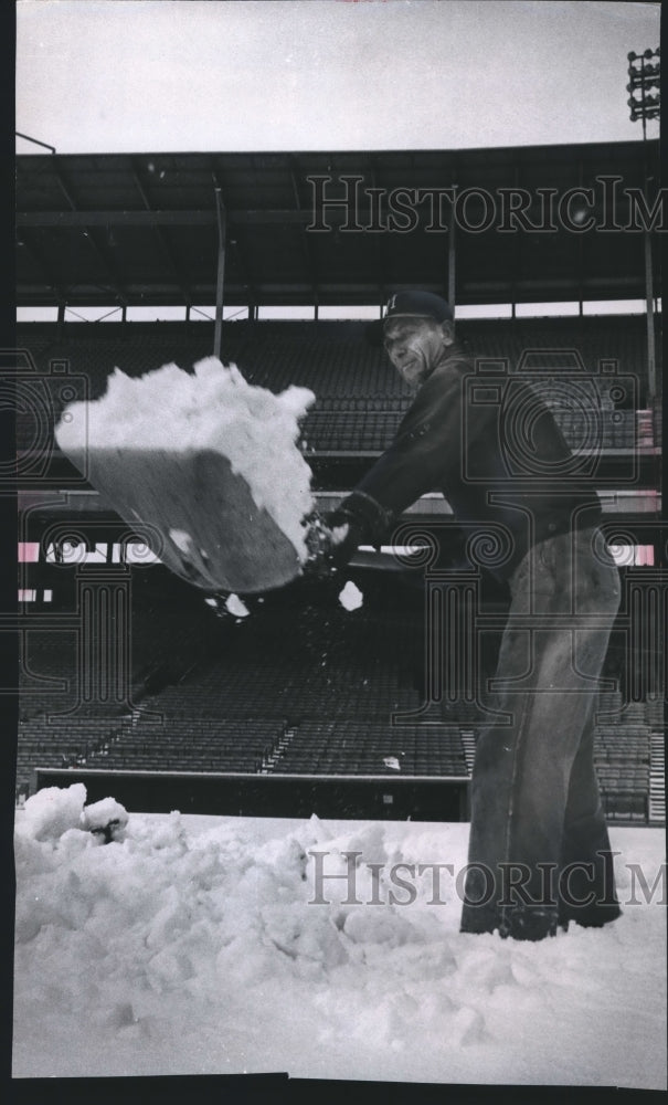 1964 Press Photo Jack Turan, of maintenance shovels snow in Stadium, Milwaukee.- Historic Images