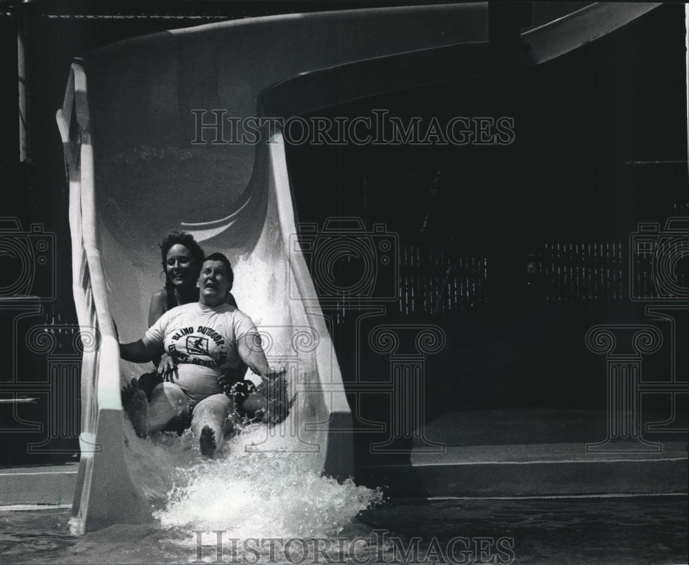 1968 Press Photo Pat Beaumont Slides with Lifeguard Kristine Evans at Hoyt Park- Historic Images