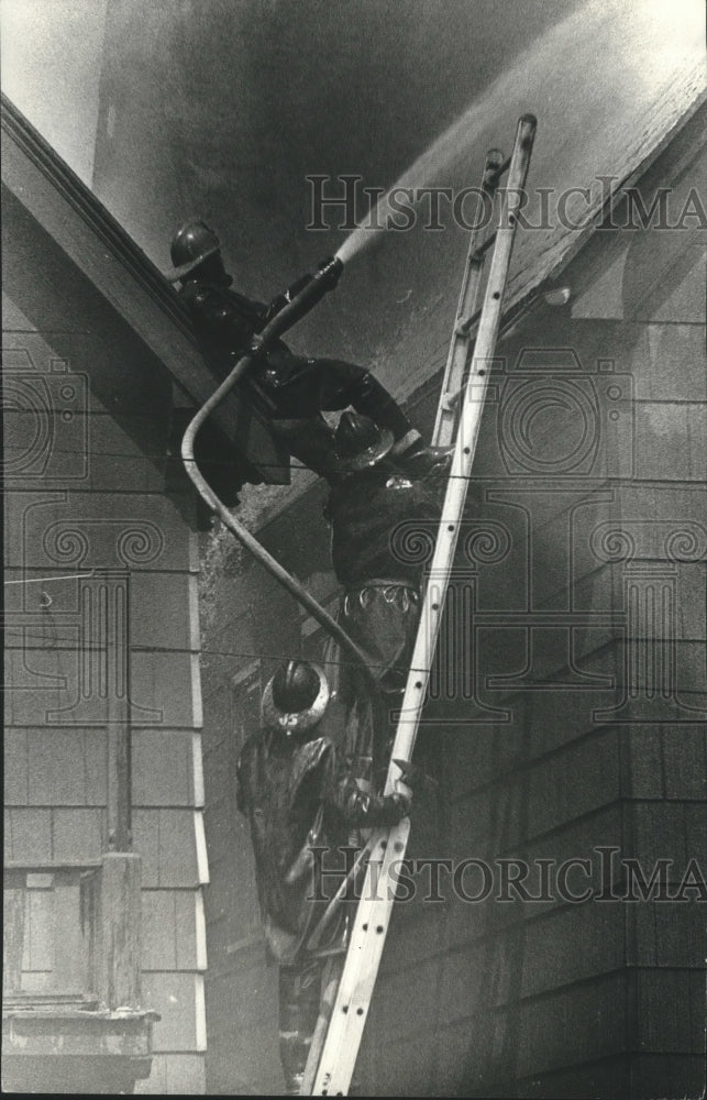 1972 Press Photo Milwaukee firefighters spray water on homes on W. North Ave.- Historic Images