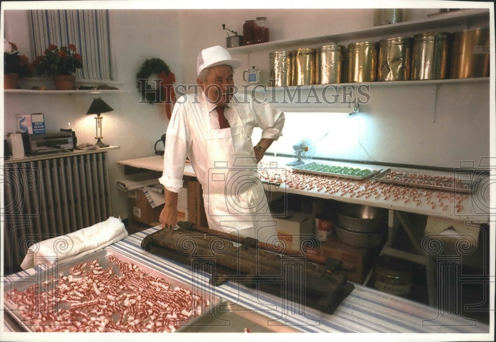 1993 Press Photo Bill Niemann relaxes on candy cutting machine in Wauwatosa- Historic Images