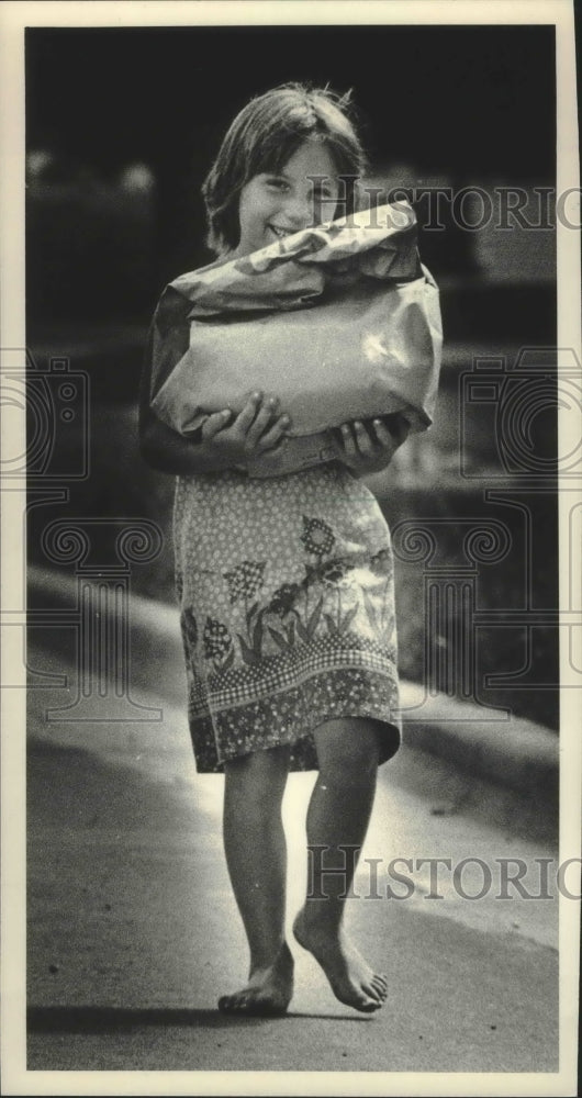 1983 Press Photo Girl carries sack in Muscoda Wisconsin- Historic Images