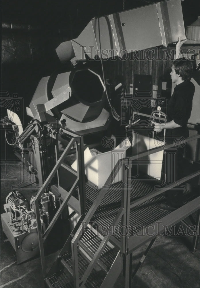 1986 Press Photo John Kobe at NES plant Waukesha load parts into chute- Historic Images