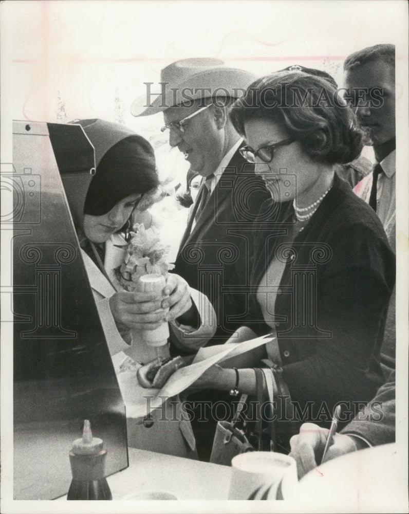 1964 Press Photo Miss Luci Johnson puts mustard on a hot dog for an aid with her- Historic Images