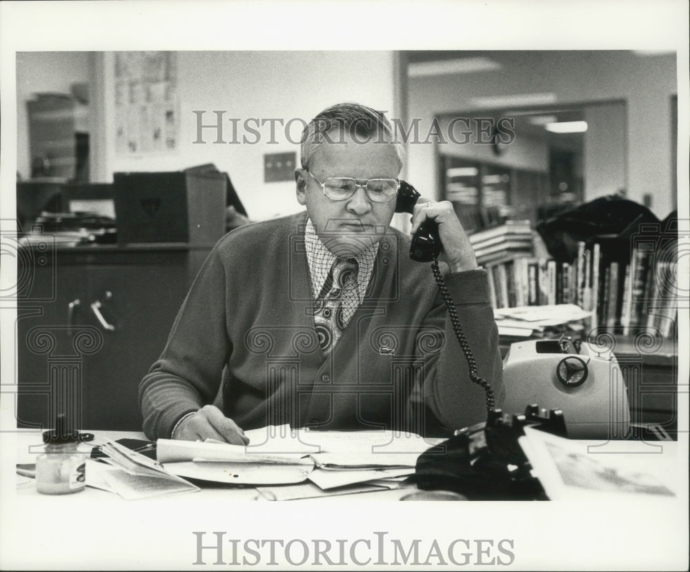 1975 Press Photo Charles &quot;Chuck&quot; Johnson in Sports Department, on phone.- Historic Images