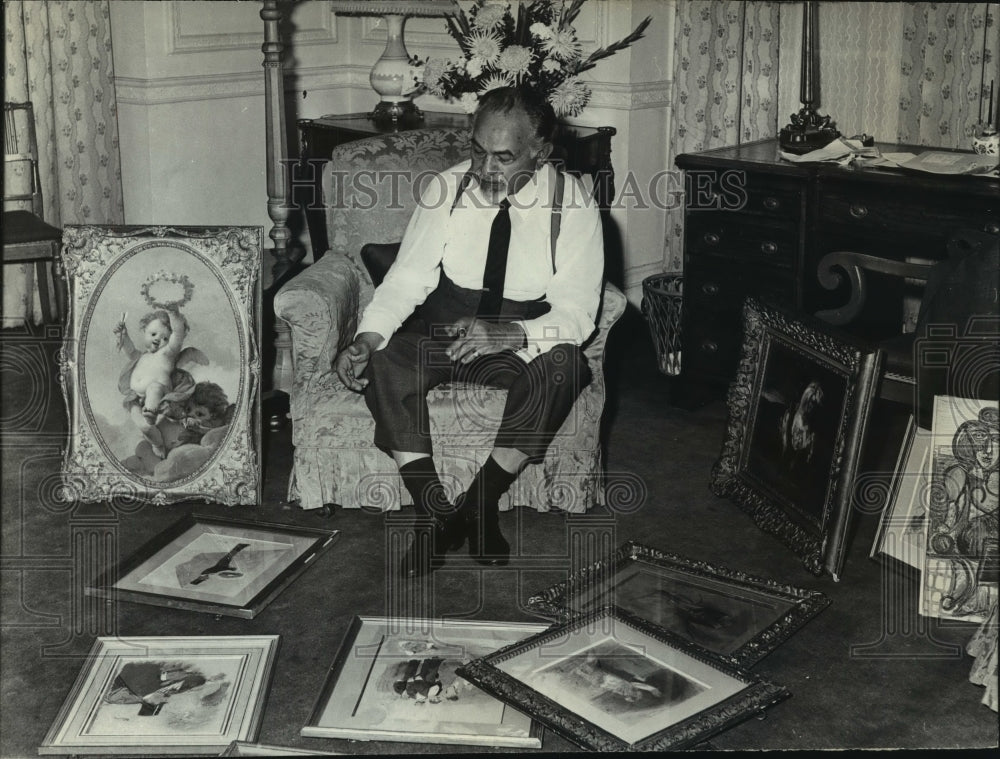 1966 Press Photo Edward Robinson looks over paintings in his London hotel room.- Historic Images